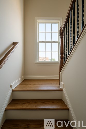A staircase with wooden steps and a window above.