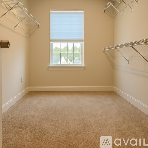 Empty room with a window and a carpeted floor.