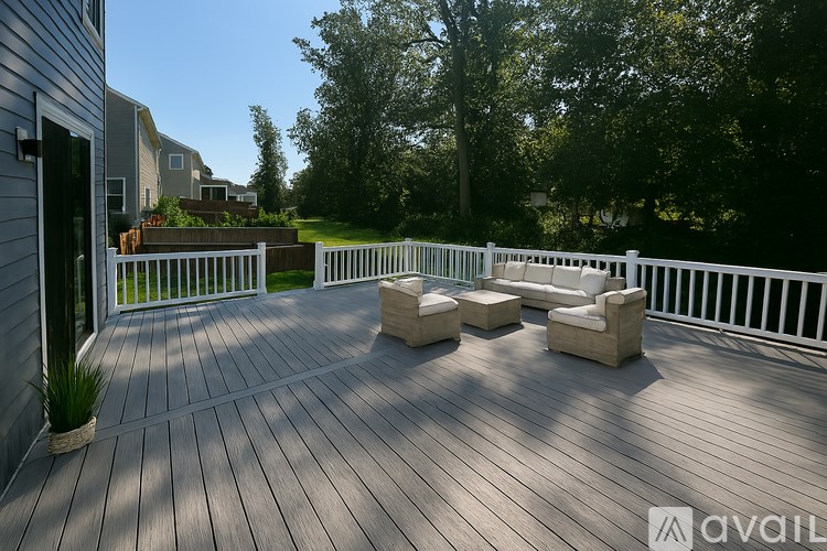 A wooden deck with white railings and a white couch.