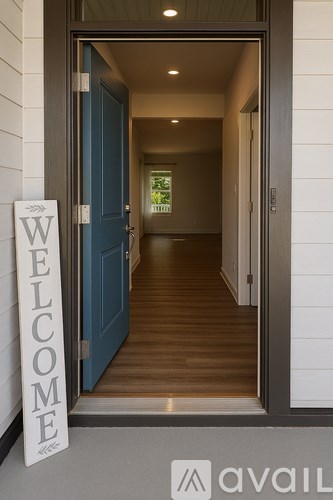 A welcome sign is on the floor next to a door.