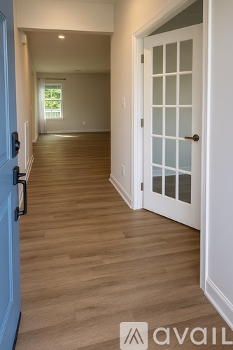 A hallway with a blue door on the left and a white door on the right.