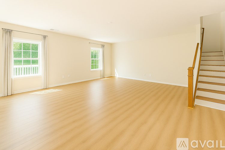 A room with wooden floors and a staircase.