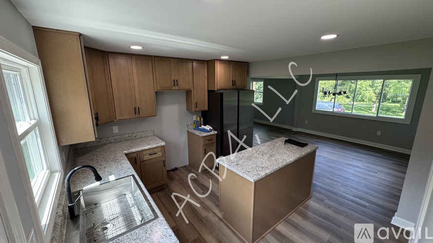 A modern kitchen with wooden cabinets and a granite countertop.