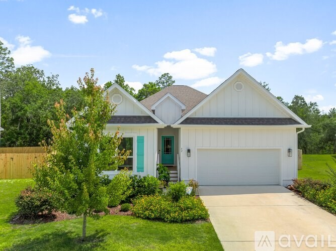 A white house with a green door and a brown roof.