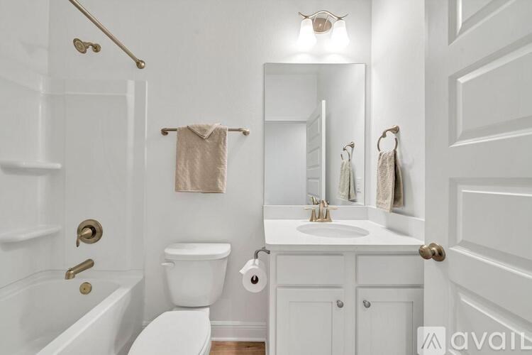 A white bathroom with a towel hanging on the towel rack.