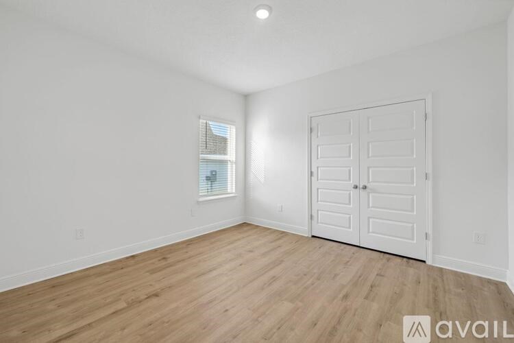 A room with a white door and a window with blinds.