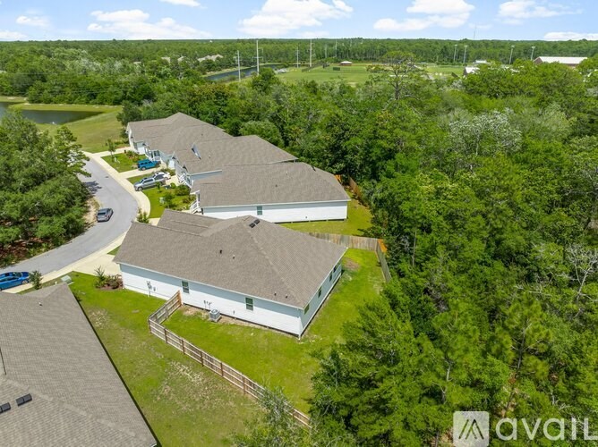 A house with a grey roof is surrounded by greenery.
