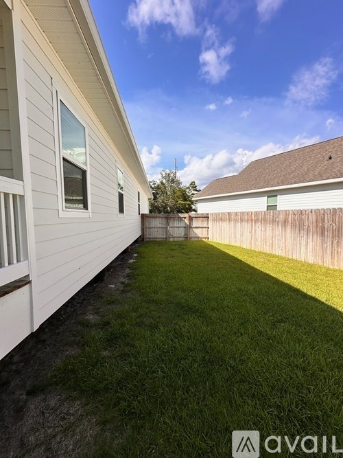 A backyard with a wooden fence and a house.