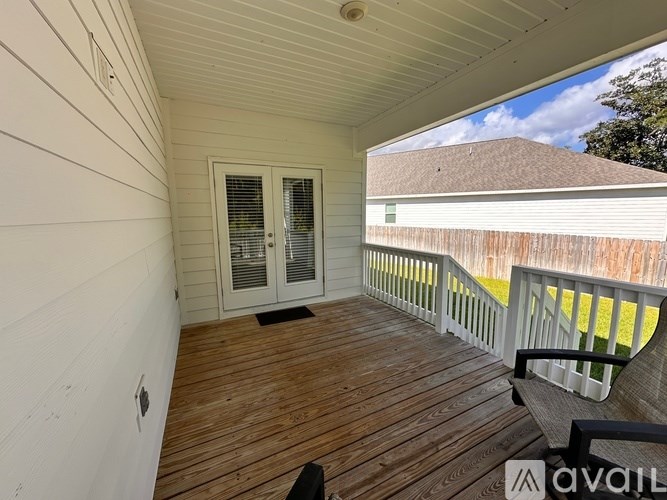 A wooden deck with a sliding glass door and a white wall.