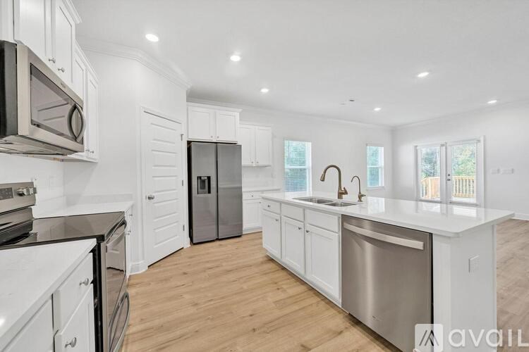 A modern kitchen with stainless steel appliances and white cabinets.