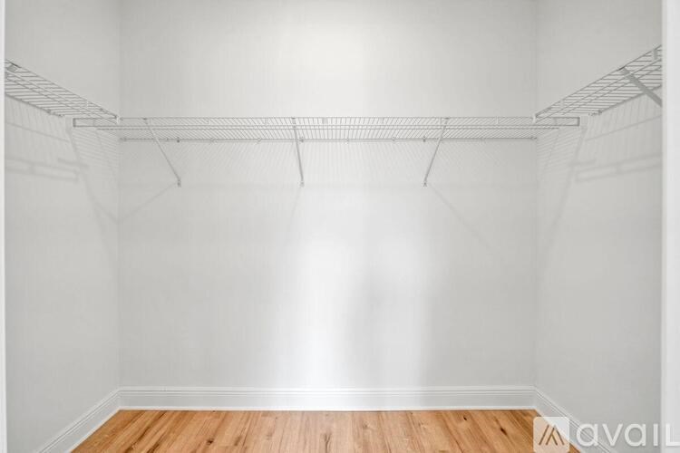 Empty room with a white wall and a wooden floor.