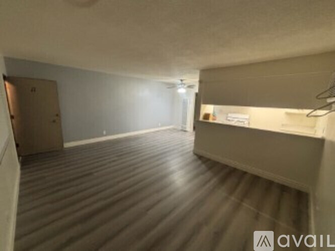 A room with a wooden floor and a door on the left side.