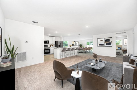 A modern living room with a dining area and kitchen in the background.