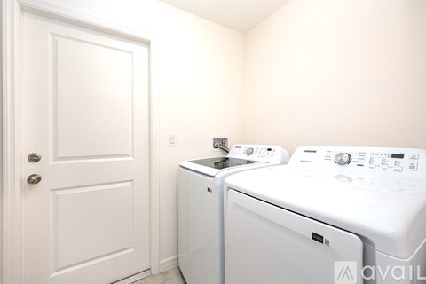 A white door is on the left of a washing machine.