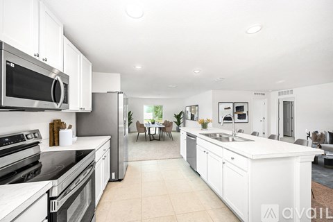 A modern kitchen with white cabinets and appliances.