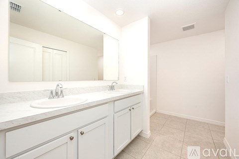 A bathroom with a sink, mirror, and cabinets.