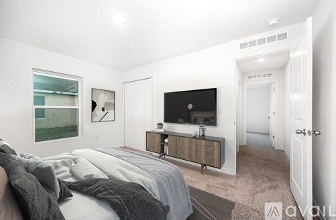 A bedroom with a bed, a dresser, and a window.