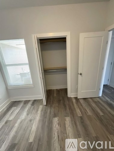 A room with a white door and a window with blinds.