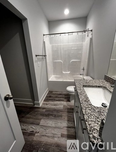 A bathroom with a walk-in shower, toilet, and sink.
