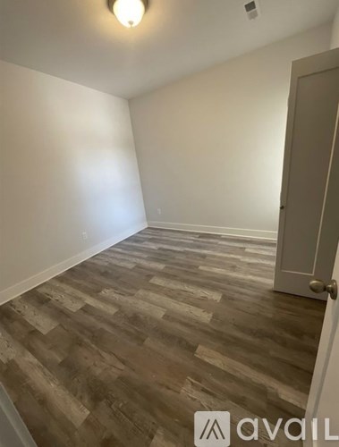 A room with a wooden floor and a closed door.