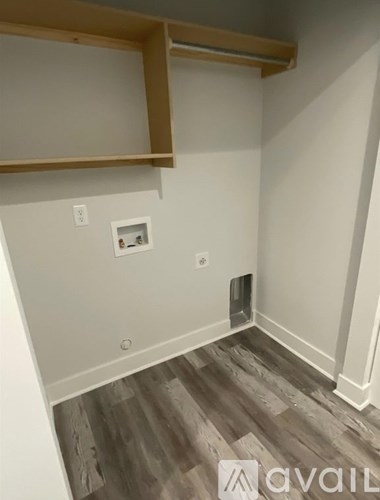 A room with a wooden floor and a shelf above it.