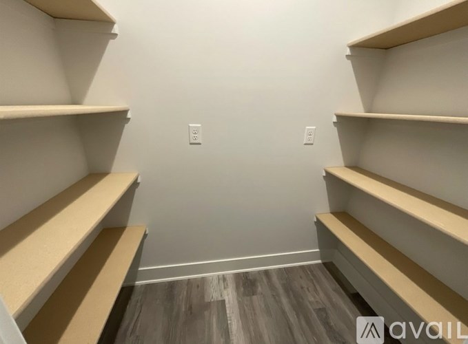Empty shelves in a room with wooden flooring.