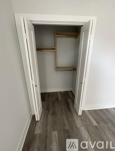 A white door is open to a room with a shelf.