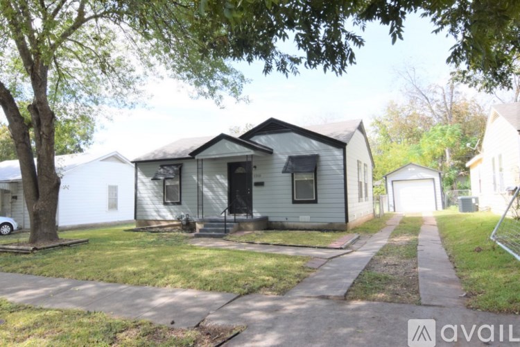A house with a tree in front of it is for sale.