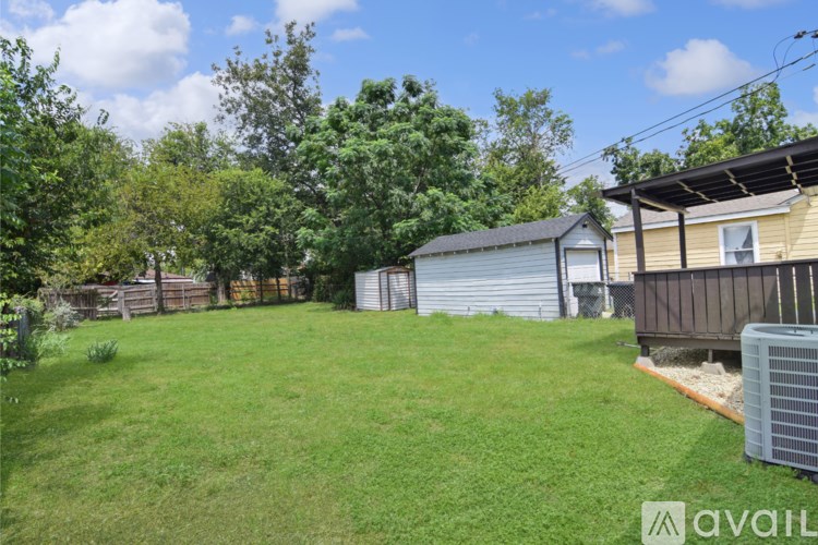 A backyard with a shed and a fence.