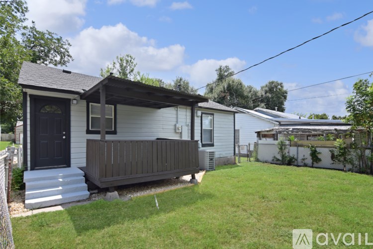 A small house with a porch and a black door.