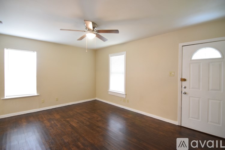 A room with wooden flooring and a ceiling fan.