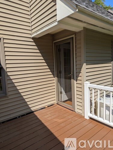 A deck with a white railing and a sliding glass door.