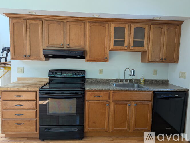 A kitchen with wooden cabinets and black appliances.