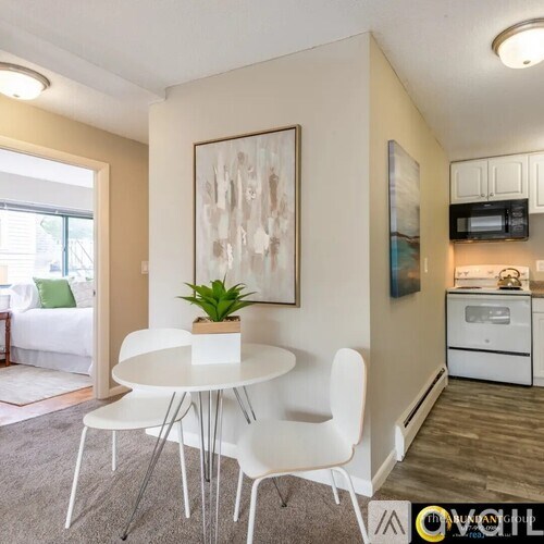 A dining area with a white table and chairs.