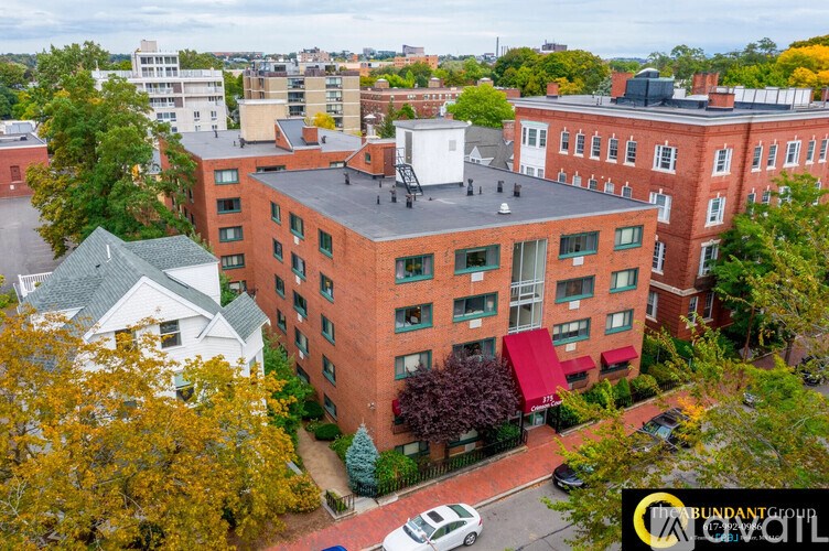 A red brick building with a white car parked in front.