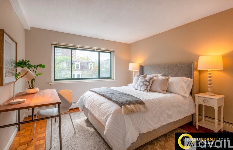 A bedroom with a bed, desk, and chair.