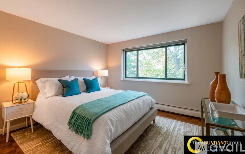 A bedroom with a large bed and a window.