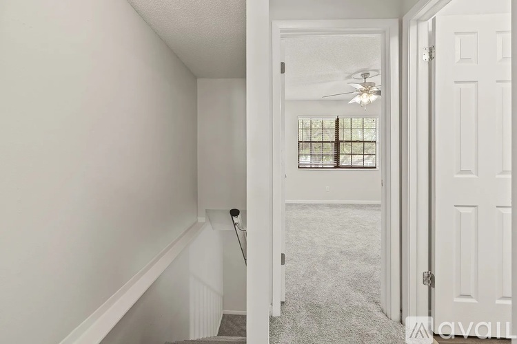 A hallway with a staircase leading to a bedroom.