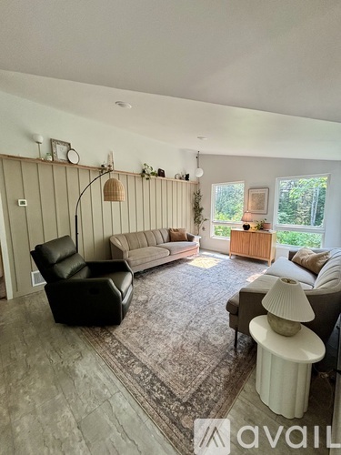 A living room with a black leather chair and a grey sofa.
