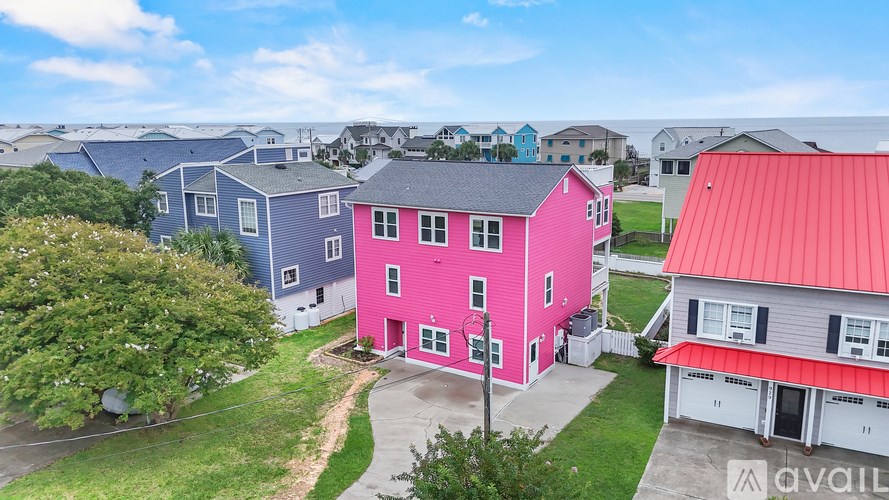 A pink house stands out in a row of blue houses.