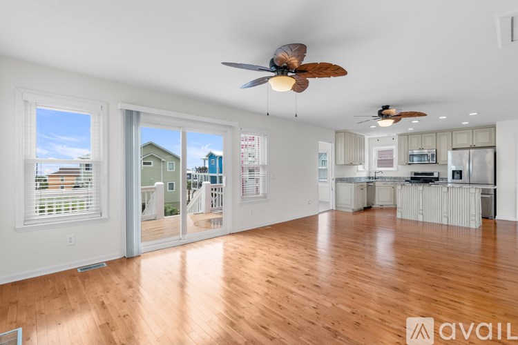 A spacious living room with hardwood floors and a ceiling fan.