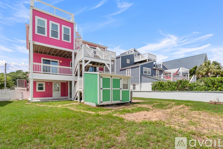 A multi-story house with a pink and green exterior.