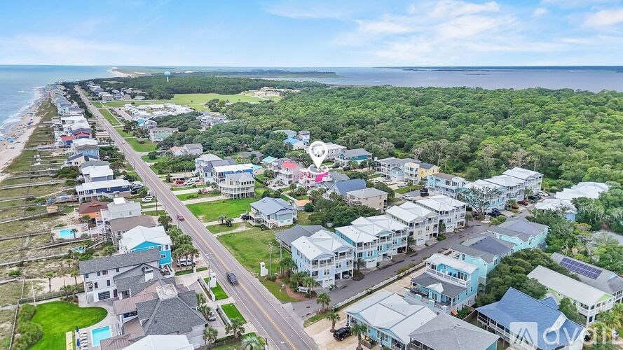 A coastal residential area with houses and greenery.