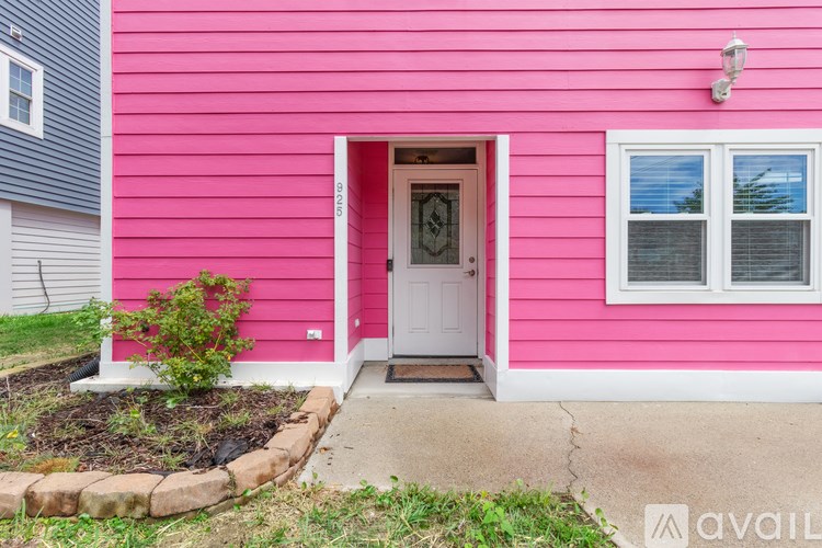 A pink house with a white door and window.