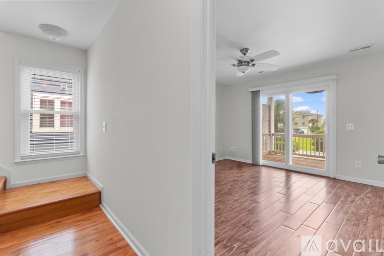 A room with wooden floors and a ceiling fan.
