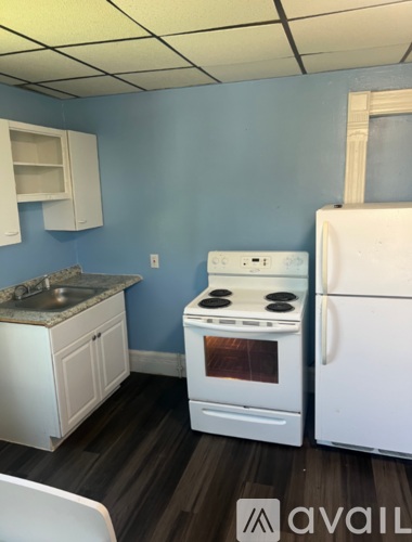 A kitchen with a white stove and a white refrigerator.