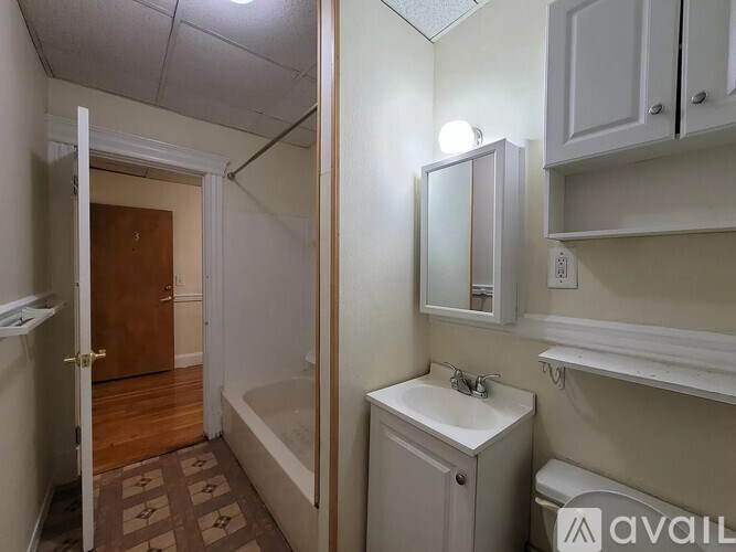 A bathroom with a toilet, sink, and bathtub.