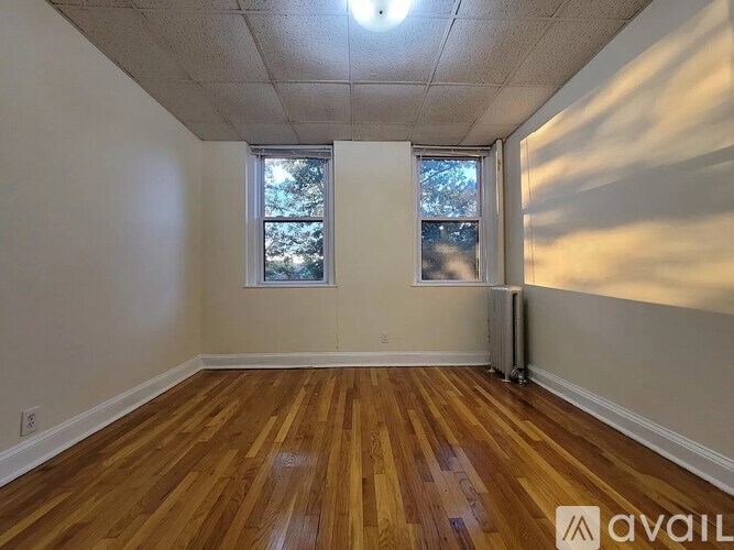 A room with wooden floors and two windows.