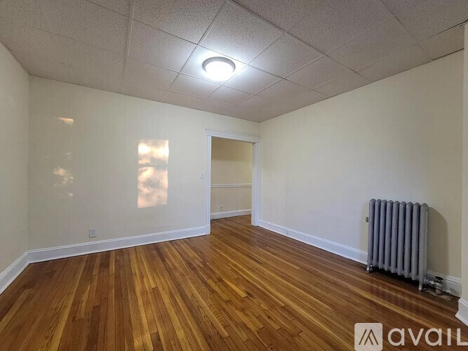A room with wooden floors and a white ceiling with a light fixture.