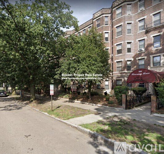 A street view of a residential area with apartment buildings and trees.